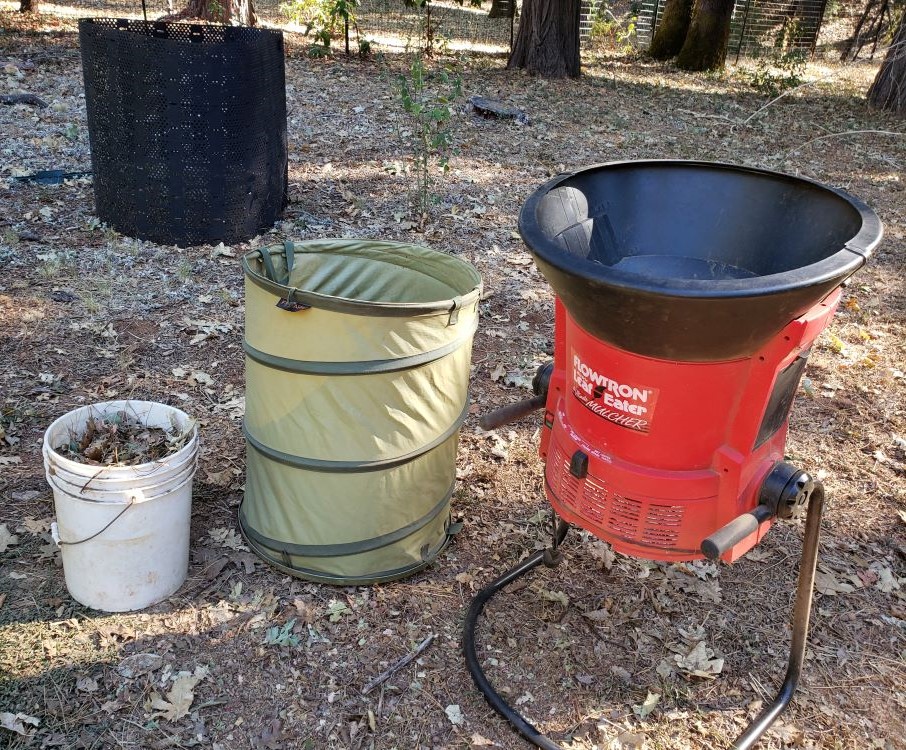 Red leaf shredder with a big container for unshredded leaves and a small bucket for shredded ones.